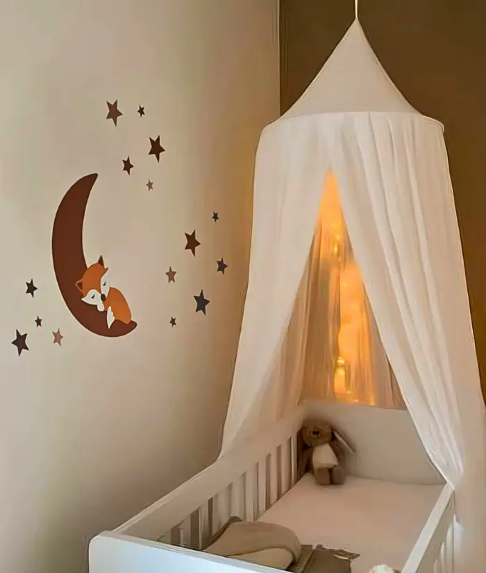 Lichte terracotta babykamer met vosjes muurdecoratie.